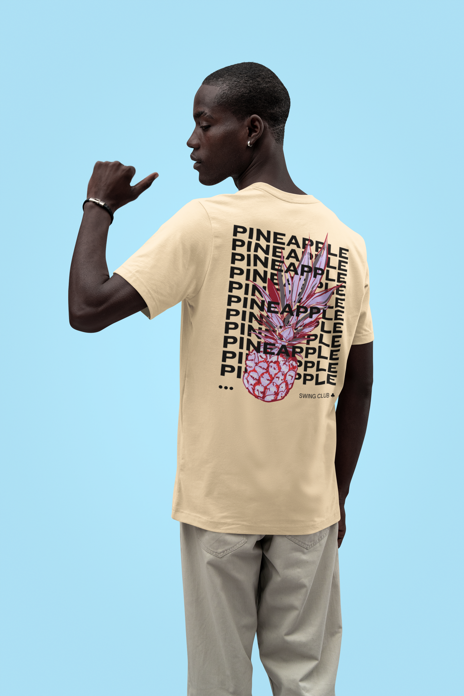 Person wearing a beige t-shirt with pineapple design and text on a blue background